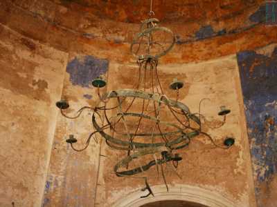 Alzando lo sguardo ci accorgiamo che proprio dal centro della calotta scende verso le nostre teste un curioso e affascinante lampadario in ferro, un tempo padrone assoluto dell�ambiente che accoglieva i fedeli in preghiera, oggi deformato dall�umidit� e dalla salsedine